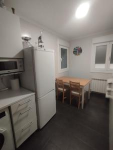 a kitchen with a white refrigerator and a table at Apartamento Markina Xemein in Marquina-Jemein +9 photos