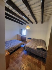 a bedroom with two beds and a table with a book at Can Cuti in Santa Eulalia de Ríuprimer