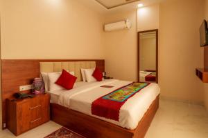 a bedroom with a large bed with red pillows at Aureva Kamla Heritage in Jaipur +37 photos
