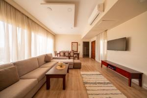 a living room with a couch and a tv at The Home Dreamland in 6th Of October