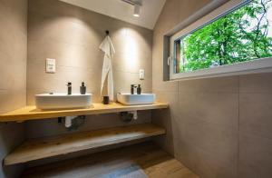 two sinks in a bathroom with a window at Chata a Chalety Starý mlyn in Veľká Franková +89 photos