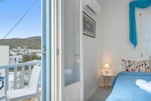 a bedroom with a bed and a balcony with a view at Angeliki Pension in Katapola