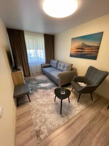 a living room with a couch and a chair at Comfort Haven Apartments in Jõhvi