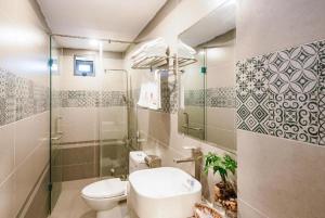 a bathroom with a toilet and a sink and a shower at The Shann Hotel Danang in Danang