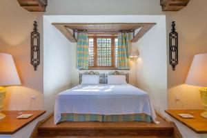 a bedroom with a bed with a window and two lamps at Villa Mitzela in Amaliapoli