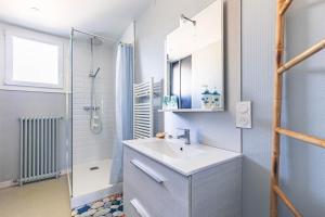 a white bathroom with a sink and a shower at Appartement À Saint-Pierre-d'Oléron in Saint-Pierre-dʼOléron