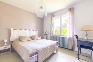 a bedroom with a bed and a desk and a window at Appartement À Saint-Pierre-d'Oléron in Saint-Pierre-dʼOléron