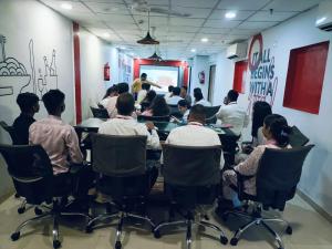a group of people sitting around a table in a room at Hotel Wow in Surat
