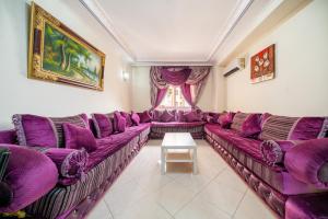 a living room with purple couches and a window at First Line Beach & Free Parking in Tangier
