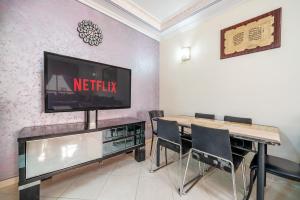 a living room with a tv and a table with chairs at First Line Beach & Free Parking in Tangier