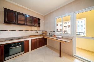 a kitchen with wooden cabinets and a counter top at First Line Beach & Free Parking in Tangier