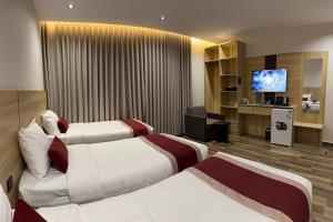 a hotel room with two beds and a flat screen tv at فندق روح المدينة in Medina