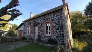 a small brick house with a window on the side at Location maison in Neussargues-Moissac