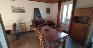 a dining room with a wooden table and chairs at Location maison in Neussargues-Moissac +5 photos