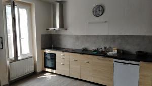 a kitchen with a sink and a stove top oven at Location maison in Neussargues-Moissac