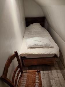 a small bedroom with a bed and a wooden chair at Location maison in Neussargues-Moissac
