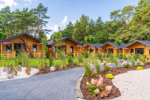 a row of cottages with flowers in a garden at Bursztynowo Mikoszewo in Mikoszewo