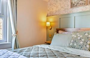 a bedroom with a bed and a window at Ivydene Cottage Hawsker in Whitby
