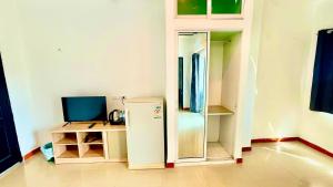 an empty room with a refrigerator and a desk at Silver Oaks Hotel in Patong Beach