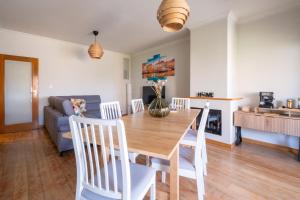 a kitchen and dining room with a wooden table and chairs at FamilyHub - EcoHost - Spacious 3-bedroom apartment for 8 people with AC and parking near Porto and the beaches in Senhora da Hora