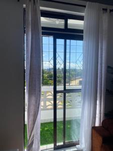 a window with white curtains and a view at Malindi Leisure homes in Malindi +1 photo