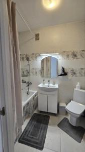 a bathroom with a sink and a tub and a toilet at Однокімнатні апартаменти в новому ЖК in Vasylʼkiv
