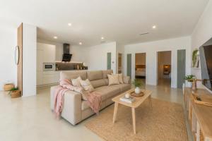 a living room with a couch and a table at Villa Las Palmeras Valdevaqueros Suites, Pool & Sea Views in Tarifa