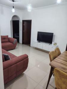 a living room with a couch and a flat screen tv at Spacious Apartment in Amman