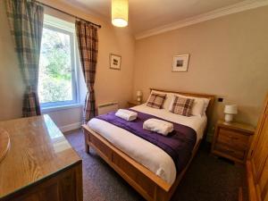 a bedroom with a bed with two towels on it at McCaig's Tower Apartment in Oban