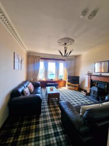 a living room with a couch and a table at McCaig's Tower Apartment in Oban