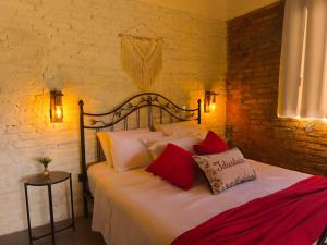 a bedroom with a bed with red and white pillows at Vale Infinito Chalé in Córrego do Bom Jesus