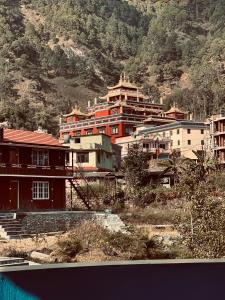 a group of buildings in front of a mountain at Prashiddha Resort in Dakshīnkāli