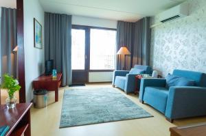 a living room with two blue chairs and a couch at Keurusselkä Resort in Keuruu