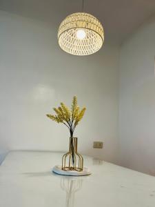 a vase sitting on a table under a light fixture at Casa Serenity Transient House in General Trias