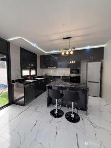 a kitchen with black and white marble floors and appliances at Villa piscine Saïdia 3 chambres in Saïdia