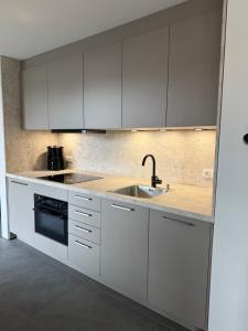 a kitchen with white cabinets and a sink at Lux Apartments in Lichtenfels