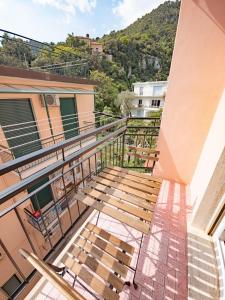 a balcony of a building with wooden benches at Noli Blue Bay in Noli
