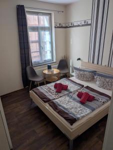 a bedroom with a bed and a table and a window at Pension Quartier 11 in Waren