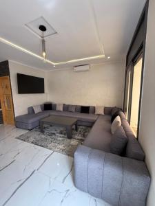 a living room with a couch and a flat screen tv at Villa piscine Saïdia 3 chambres in Saïdia
