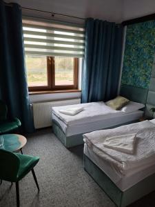a bedroom with two beds and a window at Pokoje Gościnne Pod Złotym Pstrągiem in Zgorzelec