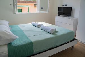 a bedroom with a bed with two towels on it at Noli Blue Bay in Noli