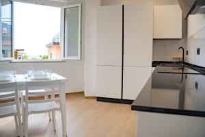 a kitchen with white cabinets and a table and chairs at Noli Blue Bay in Noli