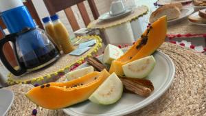 a plate of food with slices of fruit on a table at Passadeira Garden in São Tomé