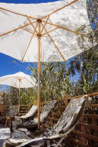 two chairs under an umbrella on a deck at Boutique Cortijo Meliora in Cantoria