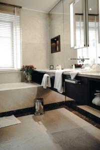 a bathroom with a tub and a sink and a mirror at Luxury Boutique Hotel Iris Porsche in Mondsee
