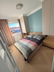 a bedroom with a bed and a large window at Olimpia Luxury Apartment in Lębork +23 photos