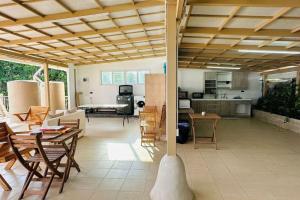 a kitchen and a living room with a table and chairs at The Rock Samui Beachfront Resort - Sha Plus Hotel in Lamai
