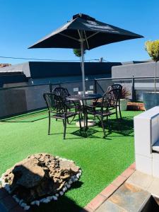 a patio with a table and chairs and an umbrella at Solovina Guest House in Foso