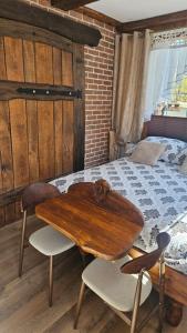 a bedroom with a wooden table and a bed at Pokój SERCE KRYNICY in Krynica Morska +10 photos