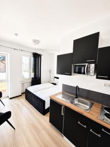 a bedroom with a bed and a kitchen with a sink at FeWo- Room Rental Rheine in Rheine